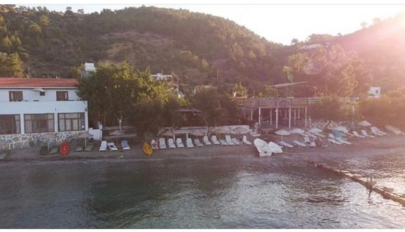 Pruva Pansiyon binası ve önündeki şezlonglu plaj, Mazı koyu, Bodrum